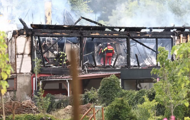 Firefighters inspect a burnt building after a fire erupted at a holiday home for disabled people in Wintzenheim, eastern France, on August 9, 2023. Eleven people were missing following a fire at a centre, where a group of adults with learning disabilities were taking their holidays, authorities said. Seventeen people were safely evacuated, with one person hospitalised and another treated for shock. (Photo by Sebastien BOZON / AFP)