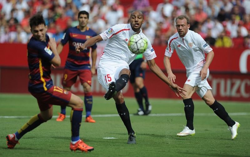 Sevilla's French midfielder Steven N'Zonzi (C) kicks the ball during the Spanish league football match Sevilla FC vs Barcelona at the Ramon Sanchez Pizjuan stadium in Sevilla on October 3, 2015.   