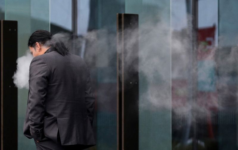Abdul Aziz, who chased the gunman of the Christchurch mosque attacks at Linwood mosque, smokes an e-cigarette as he leaves the Christchurch District Court on June 14, 2019. Brenton Tarrant, the man accused of shooting dead 51 Muslim worshippers in the Christchurch mosque attacks pleaded not guilty to multiple murder and terrorism charges on June 14, 2019 and was committed to stand trial next year. (Photo by Sanka VIDANAGAMA / AFP)