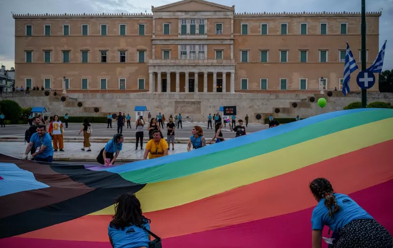 Participants hold a giant rainbow colored flag in front of the Greek parliament during the Athens Pride parade in Athens on June 10, 2023. (Photo by Angelos Tzortzinis / AFP)
