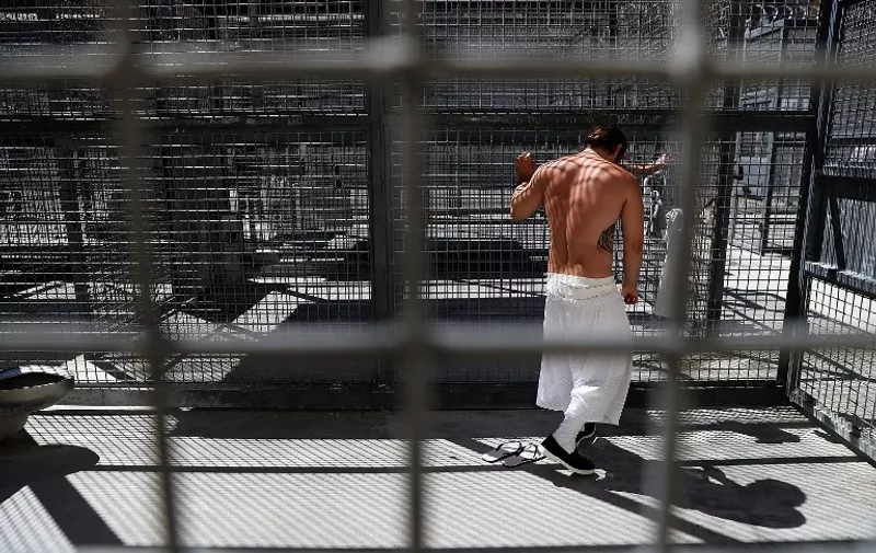SAN QUENTIN, CA - AUGUST 15: A condemned inmate stands in a cell in the yard outside of San Quentin State Prison's death row adjustment center on August 15, 2016 in San Quentin, California. San Quentin State Prison opened in 1852 and is California's oldest penitentiary. The facility houses the state's only death row for men that currently has 700 condemned inmates.   Justin Sullivan/Getty Images/AFP