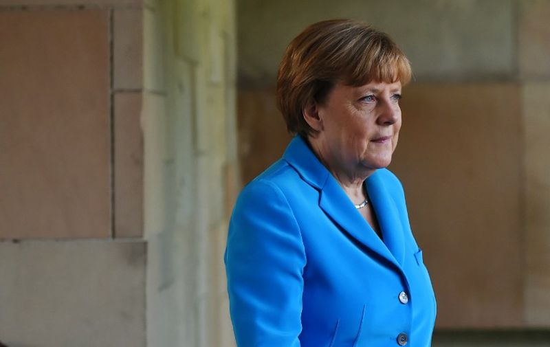 German Chancellor Angel Merkel walks at Raj Ghat -- the memorial to the father of the Indian nation Mahatma Gandhi -- in New Delhi on October 5, 2015. German Chancellor Angela Merkel landed in New Delhi for a visit in which she is expected to push for closer trade ties, and during which India's leader hopes to draw investment from the European powerhouse. AFP PHOTO /ROBERTO SCHMIDT
