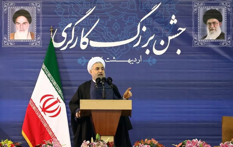 A handout picture released by the official website of the Iranian President Hassan Rouhani shows him giving a speech during a ceremony ahead of Labour Day in Tehran on April 28, 2015. Rouhani warned that middlemen who have circumvented sanctions will need to "think of another job" as a potential final nuclear deal brings changes to Iran's economy. Portraits of Iran's supreme leader, Ayatollah Ali Khamenei (R) and Iran's founder of the Islamic Republic, Ayatollah Ruhollah Khomeini, are seen in the background. AFP PHOTO / HO / IRANIAN PRESIDENCY WEBSITE   == RESTRICTED TO EDITORIAL USE - MANDATORY CREDIT "AFP PHOTO / HO / IRANIAN PRESIDENCY WEBSITE" - NO MARKETING NO ADVERTISING CAMPAIGNS - DISTRIBUTED AS A SERVICE TO CLIENTS ==