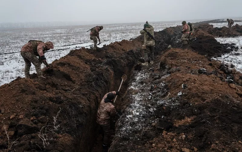Ukrainian servicemen make a trench near Bakhmut on February 1, 2023, amid the Russian invasion of Ukraine. (Photo by YASUYOSHI CHIBA / AFP)