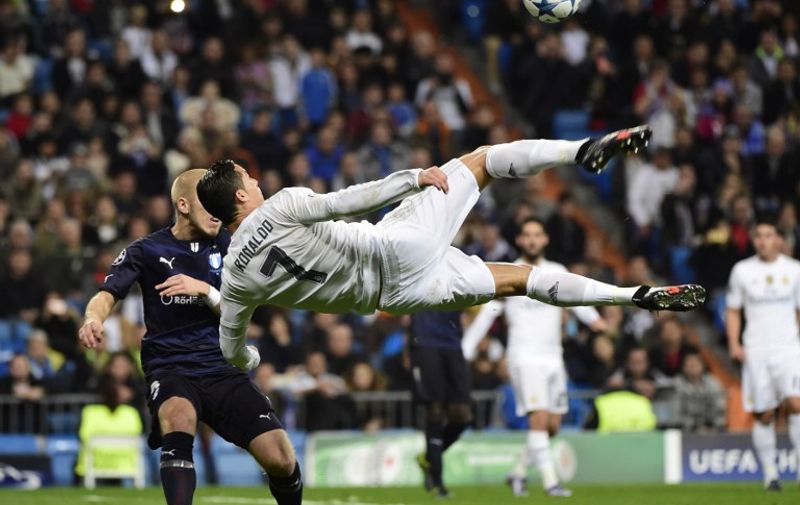 Real Madrid's Portuguese forward Cristiano Ronaldo (R) kicks the ball  during the UEFA Champions League Group A football match Real Madrid CF vs Malmo FF at the Santiago Bernabeu stadium in Madrid on December 8, 2015.   AFP PHOTO/ PIERRE-PHILIPPE MARCOU / AFP / PIERRE-PHILIPPE MARCOU
