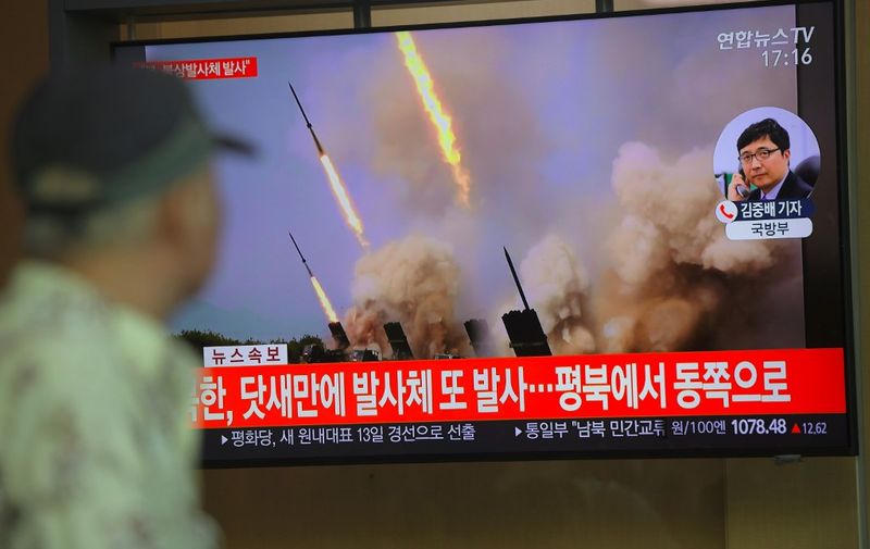 People watch a television news programme showing file footage of North Korea's projectile weapons, at a railway station in Seoul on May 9, 2019. - North Korea welcomed a US envoy's visit to Seoul by firing at least one projectile for the second time in just six days on May 9, the South's military said, as Pyongyang seeks to up the ante in deadlocked nuclear negotiations with Washington. (Photo by Jung Yeon-je / AFP)