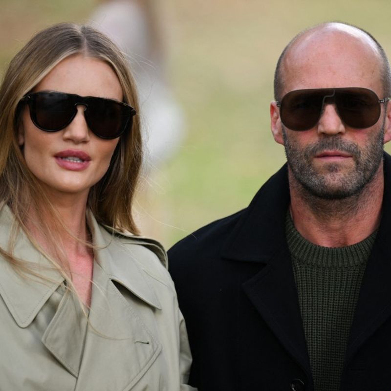 British actor Jason Statham (R) and his partner British actress and model Rosie Huntington-Whiteley (L) arrive to attend the catwalk presentation for British fashion house Burberry's Spring/Summer 2024 collection, at London Fashion Week in London, on September 18, 2023. (Photo by Daniel LEAL / AFP)