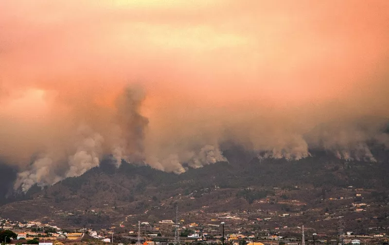 Columns of smoke, pictured from the village of Guimar, on August 17, 2023, billow from a huge wildfire which broke out almost two days ago and is raging in the northeastern part of the Canary island of Tenerife. The huge wildfire ravaging the Spanish holiday island of Tenerife that has burnt through more than 2,600 hectares of land is the "most complex" blaze to hit the Canary Islands in four decades, the regional government said today. (Photo by DESIREE MARTIN / AFP)