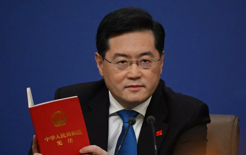 (FILES) China's Foreign Minister Qin Gang holds a copy of China's constitution during a press conference at the Media Center of the National People's Congress (NPC) in Beijing on March 7, 2023. Qin Gang, handpicked by President Xi Jinping as foreign minister, was abruptly replaced in July by the veteran policymaker Wang Yi. (Photo by NOEL CELIS / AFP)