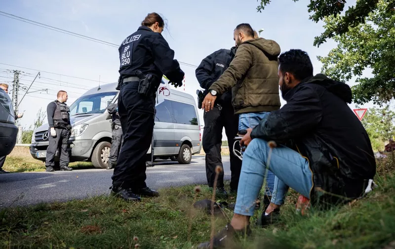 Officers of the German Federal Police (Bundespolizei) check migrants near Forst, eastern Germany on October 11, 2023, during a patrol near the border with Poland. (Photo by JENS SCHLUETER / AFP)