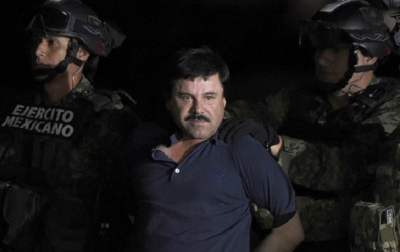 (FILES) In this file photo taken on January 8, 2016, Drug kingpin Joaquin "El Chapo" Guzman is escorted into a helicopter at Mexico City's airport, following his recapture during an intense military operation in Los Mochis, in Sinaloa State. - As a child living in poverty in Mexico, he peddled fruit just to eat. A lifetime later, as the world's most wanted drug lord, his empire was so vast he commanded a fleet of submarines to move his wares. Now, it is reckoning time for Joaquin "El Chapo" Guzman, who will go on trial Monday in New York and faces life in prison if convicted of charges that for 25 years he flooded the United States with tons of cocaine, marijuana, heroin and methamphetamine. (Photo by ALFREDO ESTRELLA / AFP)