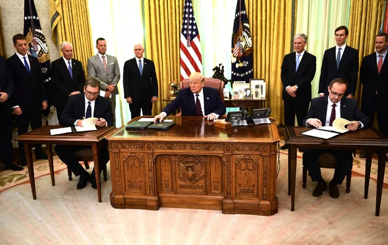 US President Donald Trump watches as Kosovar Prime Minister Avdullah Hoti (R) and Serbian President Aleksandar Vucic (L) sign an agreement on opening economic relations, in the Oval Office of the White House in Washington, DC, on September 4, 2020. (Photo by Brendan Smialowski / AFP)