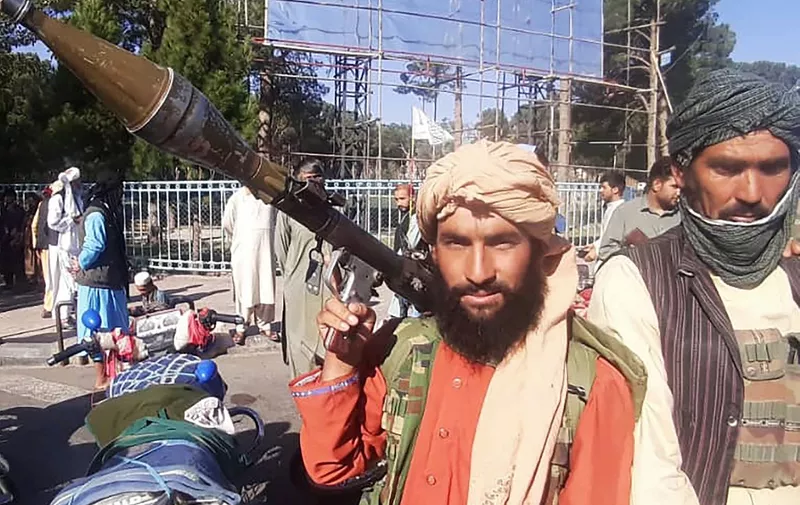 In this picture taken on August 13, 2021, a Taliban fighter holds a rocket-propelled grenade (RPG) along the roadside in Herat, Afghanistan's third biggest city, after government forces pulled out the day before following weeks of being under siege. (Photo by - / AFP)