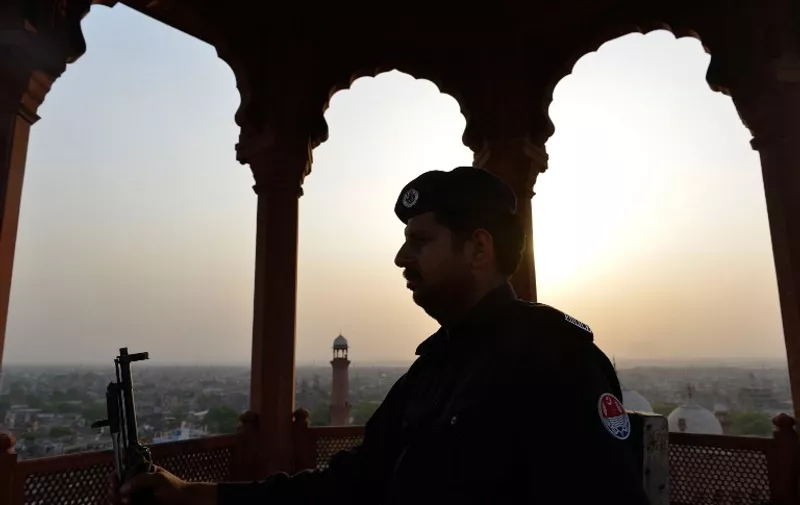 A Pakistani policeman stands guard during evening prayers at the historical Badshahi mosque in Lahore on April 25, 2015, led by the Saudi Arabian Imam of the Grand Mosque in Mecca Sheikh Khalid al Ghamdi. Sheikh Khalid al Ghamdi arrived in Pakistan to meet with senior leaders of the ruling Pakistan Muslim League-Nawaz (PML-N). AFP PHOTO / Arif ALI / AFP / Arif Ali