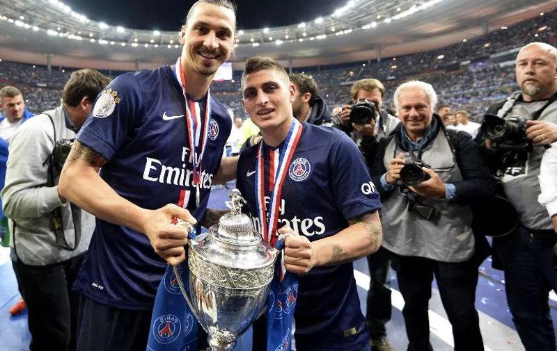 Paris Saint-Germain's Swedish forward Zlatan Ibrahimovic (L) and Paris Saint-Germain's Italian midfielder Marco Verratti (C) pose with the trophy at the end of the French Cup final football match between Paris Saint-Germain and Auxerre on May 30, 2015 at the Stade de France in Saint-Denis, north of Paris. AFP PHOTO / FRANCK FIFE