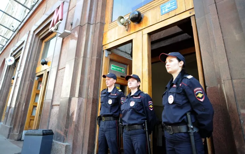 Police stand guard at the entrance to the Okhotny Ryad metro station on the red line in Moscow on June 5, 2013. Thousands of commuters were evacuated from the Moscow metro on June 5 after a high-voltage electric cable caught fire, filling station platforms with smoke at the height of the rush hour. The emergencies ministry said around 4,500 people were evacuated after the fire broke out in a tunnel between the Okhotny Ryad and Biblioteka Imeni Lenina (Lenin Library) stations on a red line close to the Kremlin at around 8:20 am (0420 GMT).   AFP PHOTO / YURI KADOBNOV / AFP PHOTO / YURI KADOBNOV