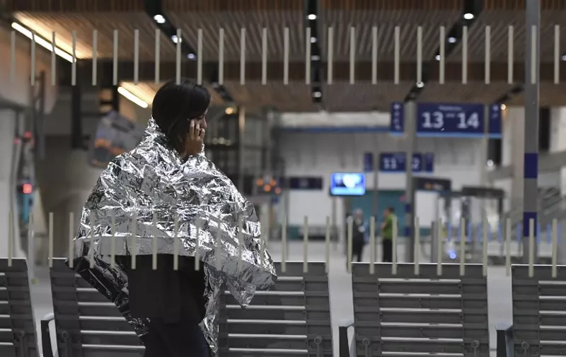A woman wearing an emergency blanket talks on her phone at London Bridge train station on June 3, 2017 following a terror attack. 
Armed police opened fire during what they described as a "terrorist" attack in central London Saturday after reports of stabbings and a van ploughing into pedestrians just days ahead of a general election. / AFP PHOTO / Chris J Ratcliffe