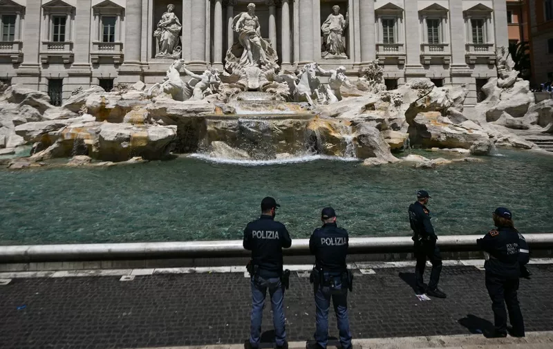Police stands guard on May 21, 2023 at the Fontana di Trevi fountain in downtown Rome after environmental activists of Last Generation (Ultima Generazione) poured black liquid made out of vegetable-based carbon into the water as part of a campaign to raise awareness about climate change. (Photo by Filippo MONTEFORTE / AFP)