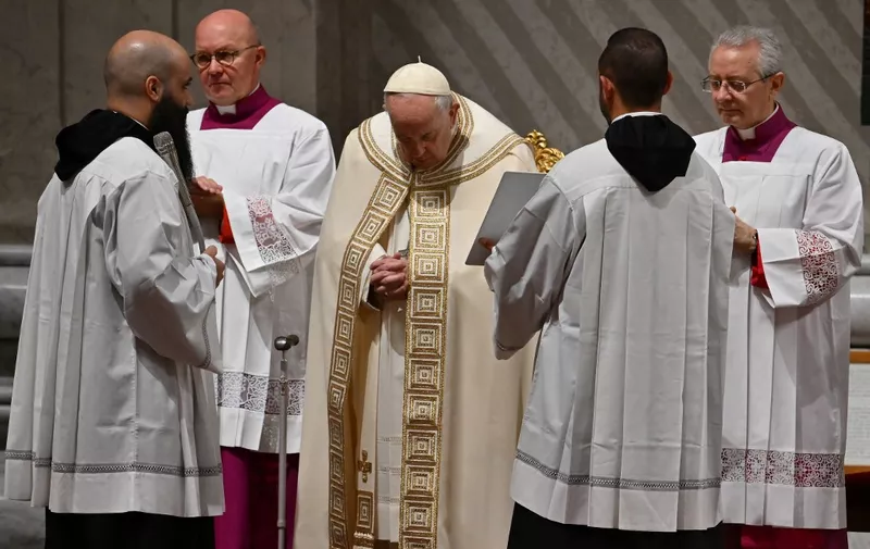 Pope Francis (C) is flanked by officials as the end of year Vespers and Te Deum prayer takes place at St. Peter's Basilica in The Vatican on December 31, 2022. - The End of year vespers at St Peters Basilica takes place as former pope Benedict XVI, who in 2013 became the first pontiff in six centuries to step down as head of the Catholic Church, died on December 31, 2022 at the age of 95, the Vatican announced. (Photo by Filippo MONTEFORTE / AFP)