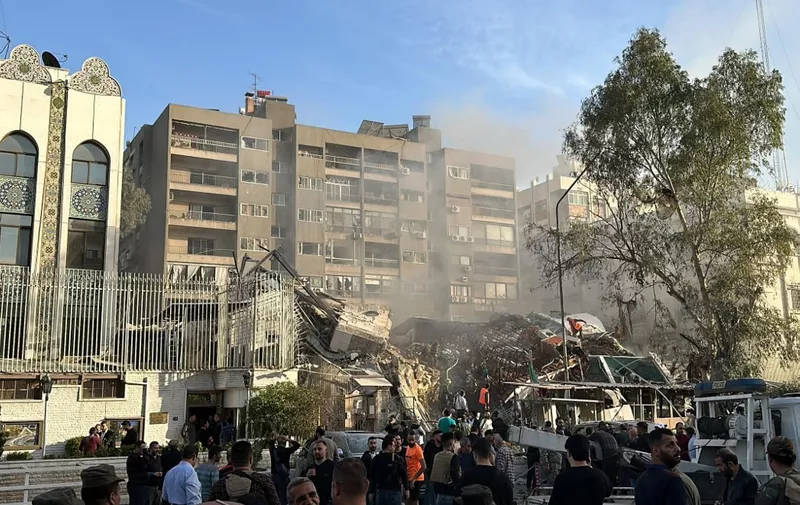 Emergency and security personnel gather at the site of strikes which hit a building adjacent to the Iranian embassy in Syria's capital Damascus, on April 1, 2024. Israeli strikes hit Syria's capital on April 1, state media reported, as a war monitor said six people were killed in a building adjacent to the Iranian embassy. (Photo by Maher AL MOUNES / AFP)