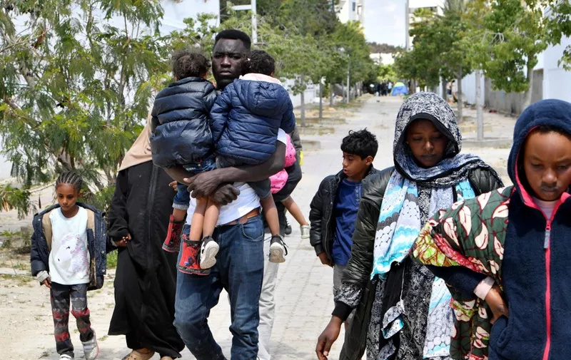 Migrants leave after Tunisian police dismantled a makeshift camp for refugees from sub-Saharan African countries in front of the UNHCR headquarters in Tunis, on April 11, 2023. (Photo by FETHI BELAID / AFP)