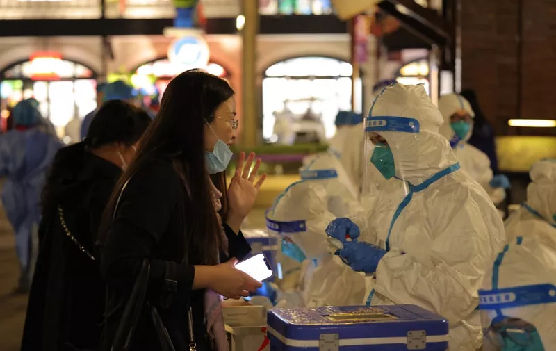 This photo taken on October 31, 2021 shows medical personnel testing visitors for the Covid-19 coronavirus at Disneyland in Shanghai after a single coronavirus case was detected at the park on the weekend. (Photo by AFP) / China OUT