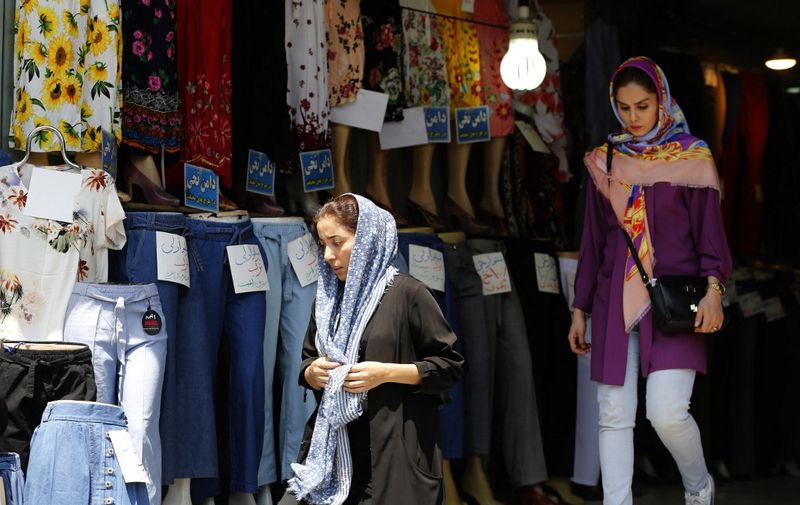 Women leave a clothing shop in the Iranian capital Tehran on August 6, 2018. - Iranian Foreign Minister Mohammad Javad Zarif said today that the leaders of the United States, Saudi Arabia and Israel were isolated in their hostility to Iran. (Photo by ATTA KENARE / AFP)
