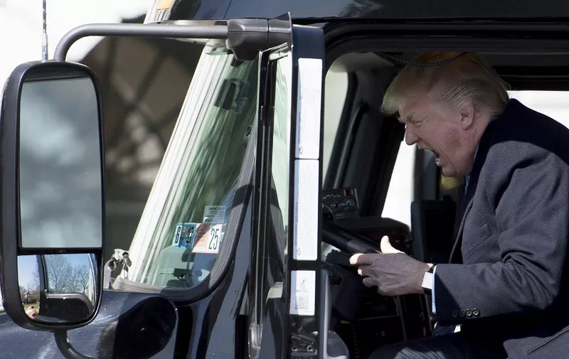 US President Donald Trump sits in the drivers seat of a semi-truck as he welcomes truckers and CEOs to the White House in Washington, DC, March 23, 2017, to discuss healthcare. (Photo by JIM WATSON / AFP) / ALTERNATIVE CROP