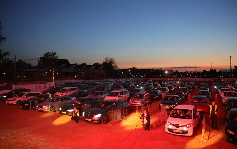 BONN, GERMANY - MAY 15: Cars parked in line and follow German singer Heino's performance during the first BonnLive drive-in concert at Am Westwerk during the Coronavirus crisis on May 15, 2020 in Bonn, Germany. The project "BonnLive Autokonzerte" is a series of drive-in concerts with musicians of different genres. The area provides space for about 200 cars. Drive-ins are becoming an increasingly popular venue for singers, theater groups, and even churches to hold events while adhering to Coronavirus lockdown measures. Two peoples are allowed to attend per vehicle and the attendees must remain in their cars. (Photo by Andreas Rentz/Getty Images)