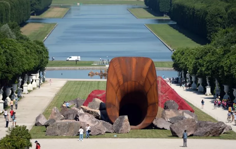 "Dirty Corner", a 2011 Cor-Ten steel, earth and mixed media monumental artwork by British contemporary artist of Indian origin Anish Kapoor, is displayed in the gardens of the Chateau de Versailles, in Versailles on June 5, 2015, as part of "Kapoor Versailles", an exhibition of Kapoor's work that runs through June 9-November 1, 2015. AFP PHOTO / STEPHANE DE SAKUTIN --RESTRICTED TO EDITORIAL USE, MANDATORY MENTION OF THE ARTIST UPON PUBLICATION, TO ILLUSTRATE THE EVENT AS SPECIFIED IN THE CAPTION --
