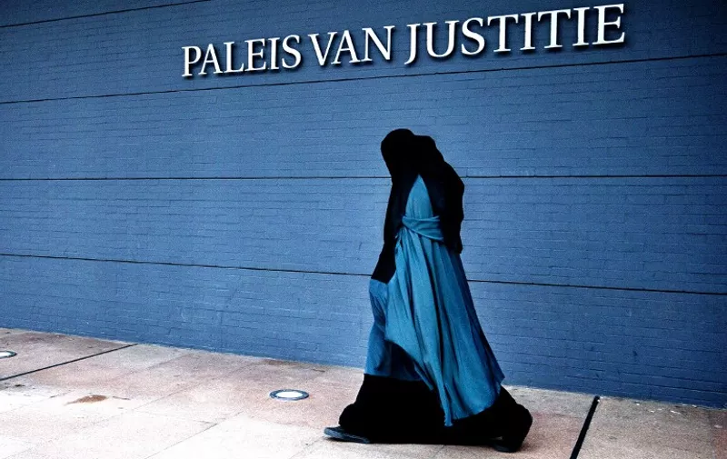 A woman wearing a burqa walks past the Palace of Justice in The Hague on December 1, 2014. The Dutch cabinet approved on May 22, 2015 a partial ban on wearing the face-covering Islamic veil, including in schools, hospitals and on public transport. AFP PHOTO / ANP PHOTO / FILER JERRY LAMPEN netherlands out