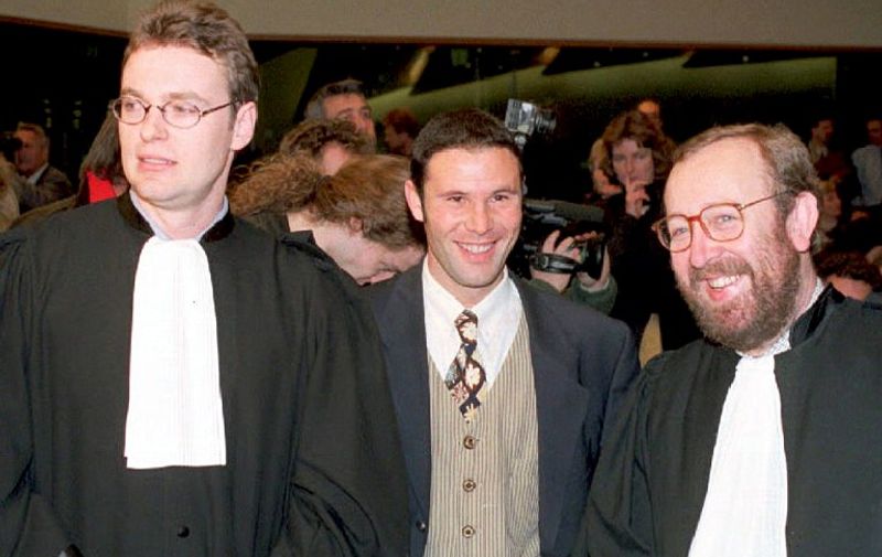(FILES) Belgian soccer player Jean-Marc Bosman, flanked by two of his lawyers Luc Misson (R) and Jean-Louis Dupont (L), smiles as the European Court of Justice rules 15 December 1995 that the transfer system of players between football clubs was illegal. The ruling of the European Court of Justice in December 1995 upheld the case brought by Jean-Marc Bosman against the European football authorities as a result of his failed transfer from a Belgian to a French club in 1990. The repercussions spread quickly through western European football as the European Union demanded that regulations concerning players' transfers and limitations on foreign players be amended almost immediately.AFP PHOTO BELGA FILES / AFP / BELGA / STF