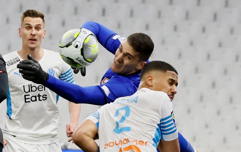 Soccer Football - Ligue 1 - Olympique de Marseille v Lille - Orange Velodrome, Marseille, France - January 16, 2022 Lille's Ivo Grbic in action with Olympique de Marseille's William Saliba REUTERS/Eric Gaillard