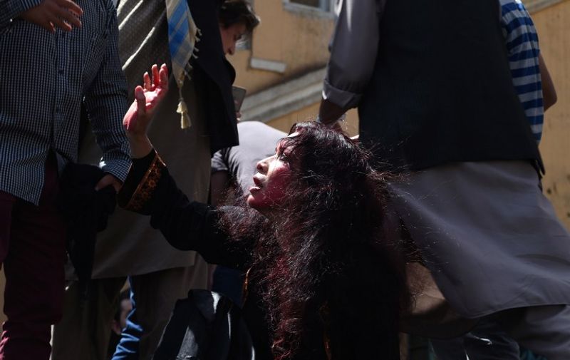 Afghan artists on April 27, 2015 perform a role play to depict the lynching of Afghan woman Farkhunda, 27, who was attacked by an angry mob, in Kabul. Farkhunda was beaten with sticks and stones, thrown from a roof, before being run over by a car outside a mosque in Kabul on March 19. The mob then set her body ablaze and dumped it in a river as police allegedly looked on. AFP PHOTO / SHAH Marai