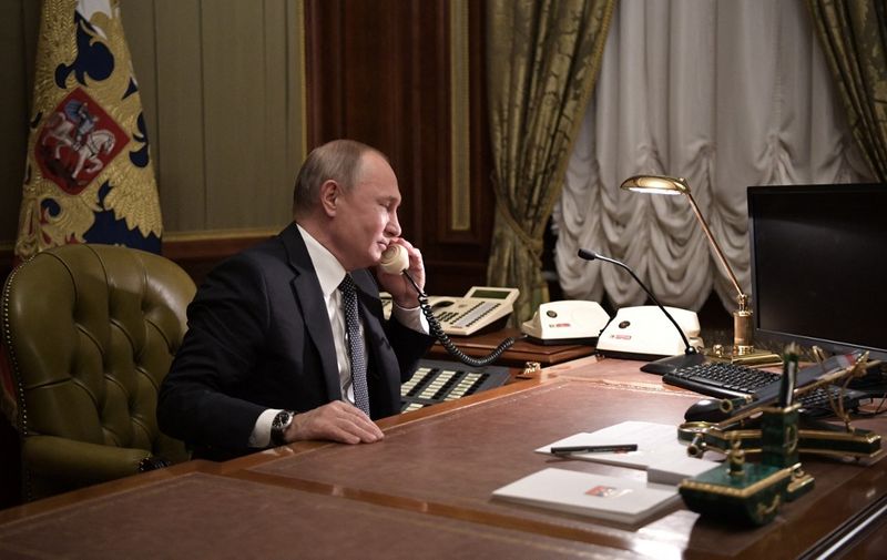 Russian President Vladimir Putin speaks on the phone in his office in Saint Petersburg on December 15, 2018 with Artyom Palyanov -- a boy with brittle bone disease who wished to see a bird's eye view of the city. - Earlier the President promised to make his dream come true by sending him on a helicopter tour of the city. (Photo by Alexey NIKOLSKY / Sputnik / AFP)