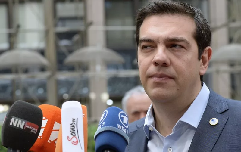 Greek Prime Minister Alexis Tsipras talks to the media as he arrives for a meeting of the leaders of the 19 countries that use the euro, in Brussels on July 12, 2015. The EU cancelled a full 28-nation summittoday to decide whether Greece stays in the European single currency as a divided eurozone struggled to reach a reform-for-bailout deal.  AFP PHOTO / THIERRY CHARLIER
