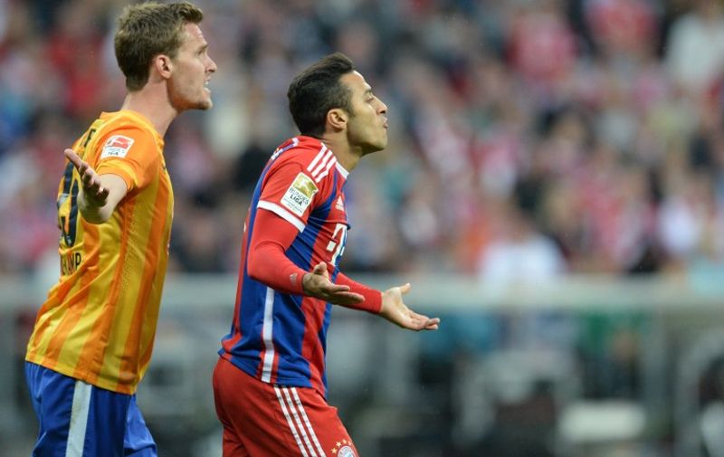 Hertha's defender Sebastian Langkamp (L) and Bayern Munich's Spanish midfielder Thiago Alcantara (R) react during the German first division Bundesliga football match between FC Bayern Munich and Hertha BSC Berlin at the Allianz Arena in Munich, southern Germany on April 25, 2015. Bayern Munich won the match 1-0. AFP PHOTO / CHRISTOF STACHE

RESTRICTIONS - DFL RULES TO LIMIT THE ONLINE USAGE DURING MATCH TIME TO 15 PICTURES PER MATCH. IMAGE SEQUENCES TO SIMULATE VIDEO IS NOT ALLOWED AT ANY TIME. FOR FURTHER QUERIES PLEASE CONTACT DFL DIRECTLY AT + 49 69 650050.
