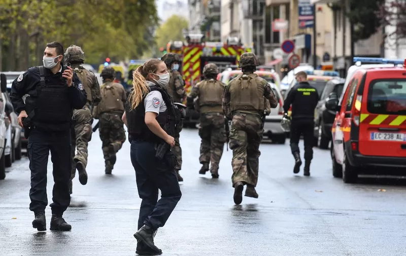 French army soldiers rush to the scene after several people were injured near the former offices of the French satirical magazine Charlie Hebdo following an alleged attack by a man wielding a knife in the capital Paris on September 25, 2020. - Four people were injured, two seriously, in a knife attack in Paris on September 25, 2020, near the former offices of French satirical magazine Charlie Hebdo, a source close to the investigation told AFP. Two of the victims were in a critical condition, the Paris police department said, adding two suspects were on the run. The stabbing came as a trial was underway in the capital for alleged accomplices of the authors of the January 2015 attack on the Charlie Hebdo weekly that claimed 12 lives. (Photo by Alain JOCARD / AFP)