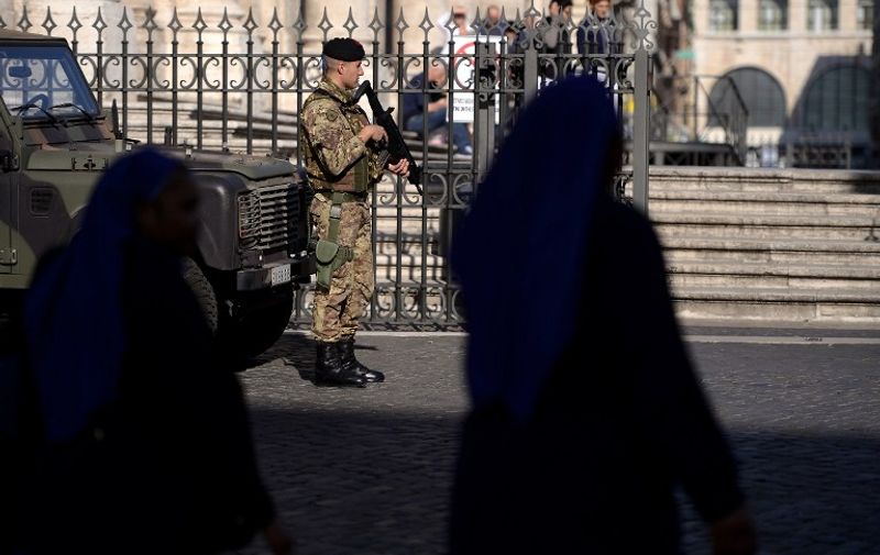 Italian soldiers patrol near the Santa Maria Maggiore Basilica in Roma on November 16, 2015. Islamic State jihadists claimed a series of coordinated attacks by gunmen and suicide bombers in Paris on November 13 that killed at least 129 people in scenes of carnage at a concert hall, restaurants and the national stadium.  AFP PHOTO / FILIPPO MONTEFORTE