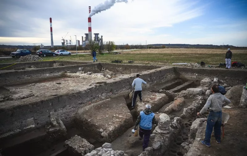 Archeologists work at an archaeological site right next to a coal mine and a power plant, in central Serbias Stari Kostolac on December 3, 2021 -- on the outskirts of what was once a major Roman settlement and military garrison then known as Viminacium. - According to archeologists, Viminacium was once the provincial capital of Romes Moesia region and supported a population of roughly 30,000 inhabitants during its heyday. For centuries, residents near Stari Kostolac have used the bricks and mosaic tiles and other pieces from antiquity that were found in abundance in the area to fill everyday needs. 
Tens of thousands of artefacts have been unearthed from the area so far, including a Roman bath with heated floors and walls, a fleet of ships, and hundreds of sculptures. (Photo by Andrej ISAKOVIC / AFP)