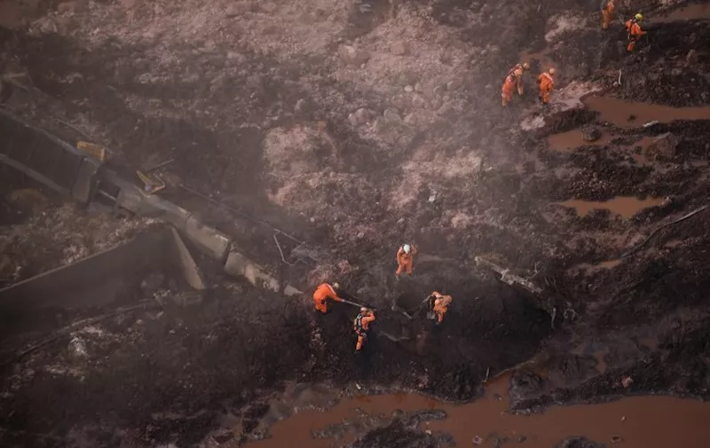 Rescuers work in the search for victims after the collapse of a dam, which belonged to Brazil's giant mining company Vale, near the town of Brumadinho in southeastern Brazil, on January 25, 2019. - A dam collapse in southeast Brazil unleashed a torrent of mud on a riverside town and surrounding farmland Friday, destroying houses, leaving 200 people missing and raising fears of a number of deaths, according to officials. (Photo by Douglas Magno / AFP)