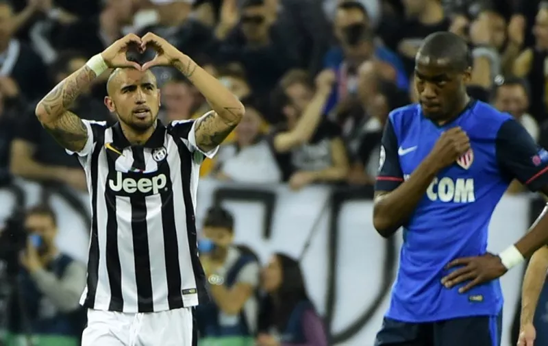 Juventus&#8217; midfielder from Chile Arturo Vidal (L) celebrates after scoring a penalty during the UEFA Champions League quarter final football match Juventus FC vs AS Monaco on April 14, 2015 at the Juventus Stadium in Turin. AFP PHOTO / OLIVIER MORIN