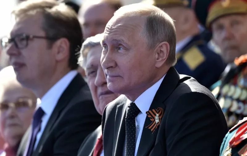 Russian President Vladimir Putin (C) and Serbian President Aleksandar Vucic watch the Victory Day military parade at Red Square in Moscow on May 9, 2018. - Russia marks the 73rd anniversary of the Soviet Union's victory over Nazi Germany in World War Two. (Photo by Alexey NIKOLSKY / SPUTNIK / AFP)