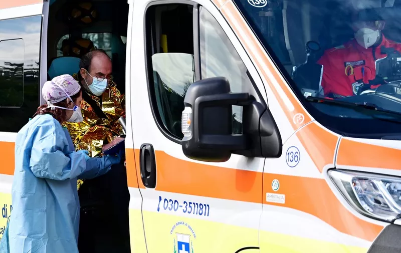 A man arrives in an ambulance at the a pre-triage medical tent in front of the Cremona hospital, in Cremona, northern Italy, on March 4, 2020. - Italy will recommend people stop kissing in public, avoid shaking hands and keep a safe distance from each other to limit the spread of the novel coronavirus. Other measures to be approved by the government, which has borne the brunt of the COVID-19 disease, includes a plan to play all football matches behind closed doors. (Photo by MIGUEL MEDINA / AFP)