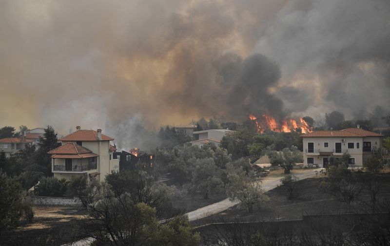 A picture taken on August 6, 2021 shows burning houses as a fire spreads in the village of Afidnes, some 30 kilometres north of Athens. - Hundreds of firefighters battled a blaze on the outskirts of Athens on August 6 as dozens of fires raged in Greece. (Photo by LOUISA GOULIAMAKI / AFP)