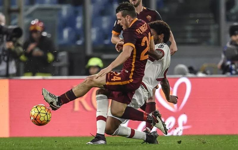 Roma's midfielder from Italy Alessandro Florenzi (L) fights for the ball against AC Milan's forward from Brazil Luiz Adriano during the Italian Serie A football match AS Roma vs AC Milan on January 9, 2016 at Rome's Olympic stadium.  / AFP / ANDREAS SOLARO