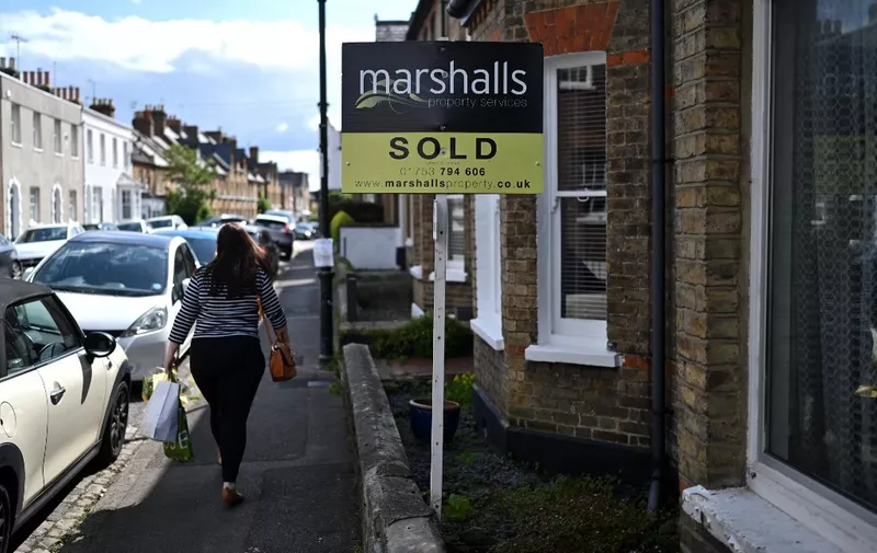 An estate agents' 'Sold' board is pictured outside of a residential property in Windsor, west of London, on July 29, 2023. Britain's central bank, The Bank of England, is set to meet on August 3 to decide what level interest rates should be set at. The Bank of England has ramped up interest rates 13 times in a row to the current level of five percent in an attempt to dampen stubbornly-high inflation. (Photo by JUSTIN TALLIS / AFP)