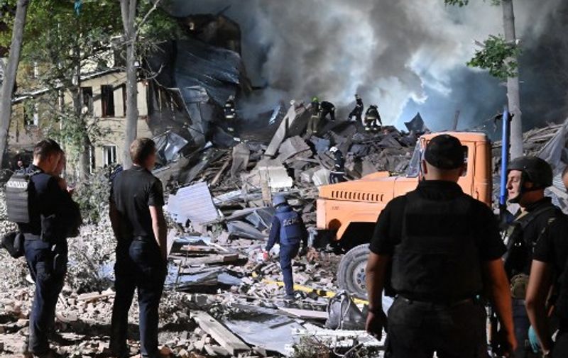 Rescue workers inspect the site of a destroyed hostel as a result of a missile strike in the second largest Ukrainian city of Kharkiv late on August 17, 2022, amid Russia's military invasion of Ukraine. (Photo by SERGEY BOBOK / AFP)