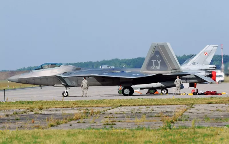 US F-22 Raptor stealth fighters are serviced at the Lask air base in central Poland on August 31, 2015. Two US F-22 Raptor stealth fighters landed in Poland , as regional tensions run high over Russia and the conflict in Ukraine. The arrival of the two planes was aired on TVP Info public television channel. They flew in from their German base of Spangdahlem into the Lask air base in central Poland. AFP PHOTO / PIOTR SIKORSKI