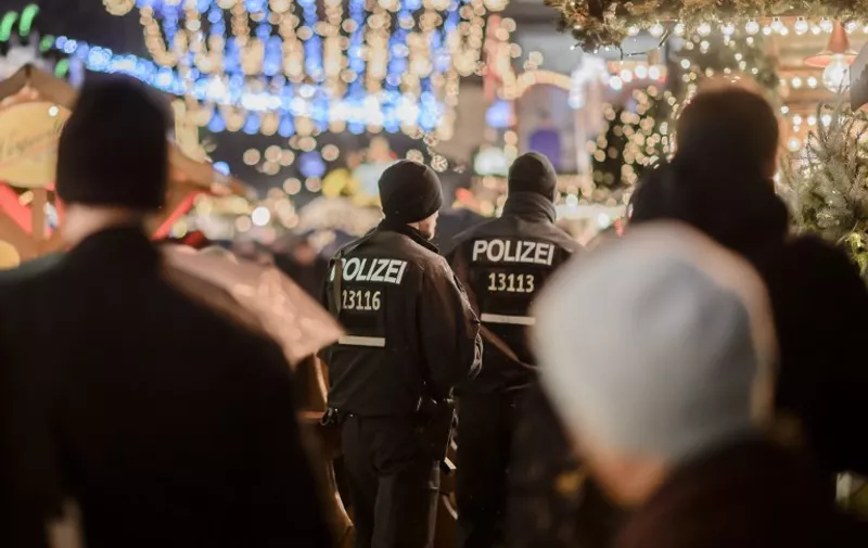 Police patrols at the reopened Christmas market near the Kaiser-Wilhelm-Gedaechtniskirche (Kaiser Wilhelm Memorial Church) in Berlin on December 22, 2016.
The Berlin Christmas market that was struck by a deadly truck rampage on December 19, 2016 reopened, as the grieving city sought a return to normal life and police hunted for the prime suspect in the attack. / AFP PHOTO / CLEMENS BILAN